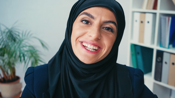 young muslim businesswoman in hijab smiling while looking at camera - Photo, Image