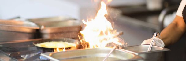 Kuchař vaření s plamenem na kuchyňském sporáku detailní up - Fotografie, Obrázek