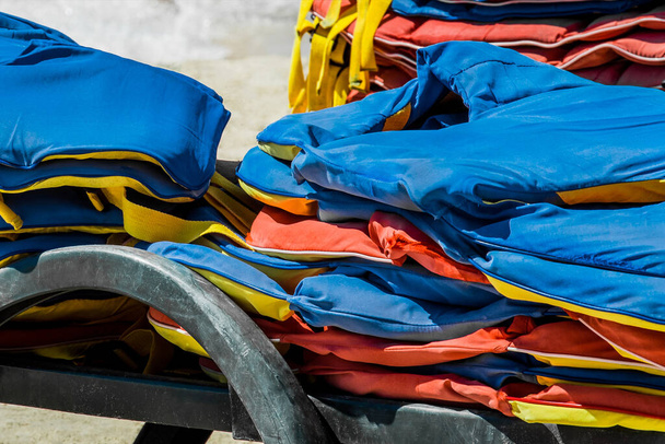 спасательные жилеты, защита и безопасность жизни на воде на фоне моря. - Фото, изображение