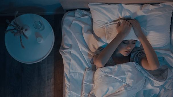 Top näkymä sairas nainen pyyhe päällä makaa sängyllä  - Valokuva, kuva