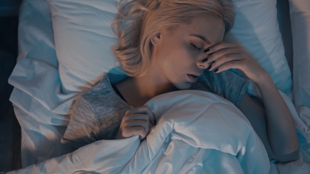 Κάτοψη της γυναίκας που υποφέρει από καταρροή ενώ κοιμάται στο κρεβάτι  - Φωτογραφία, εικόνα