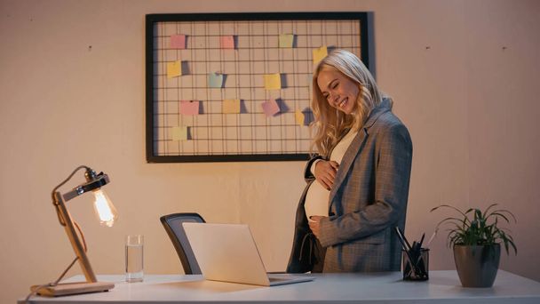 妊娠中の実業家はオフィスでラップトップでビデオ通話を持っています  - 写真・画像