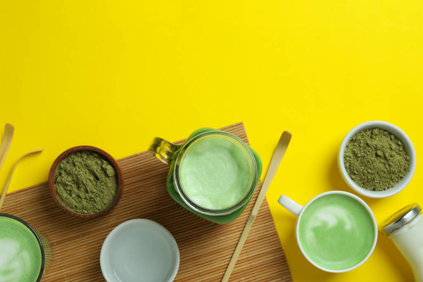 Matcha latte en accessoires voor het maken op gele achtergrond - Foto, afbeelding