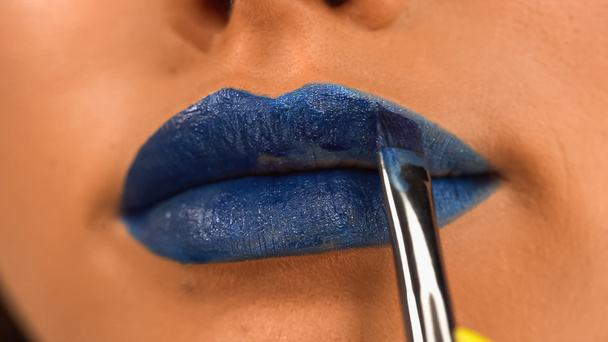 rajattu näkymä nainen soveltamalla sininen huulipuna kosmeettisia harjalla - Valokuva, kuva