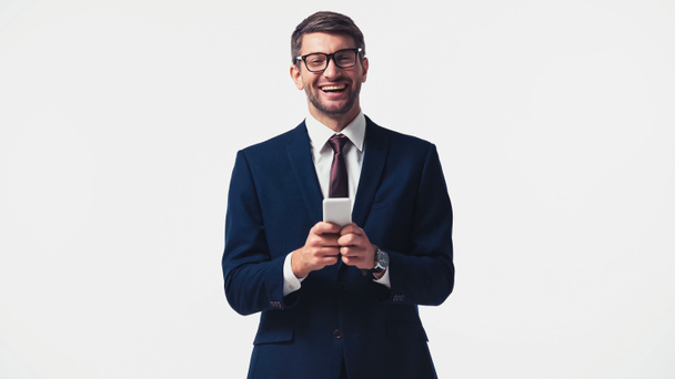 Cheerful businessman in eyeglasses holding smartphone isolated on white - Foto, Imagen