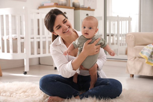 Happy young mother with her cute baby on floor at home - Φωτογραφία, εικόνα