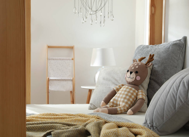 Comfortable wooden house bed with cushions and toy in child room. Interior design - Photo, image