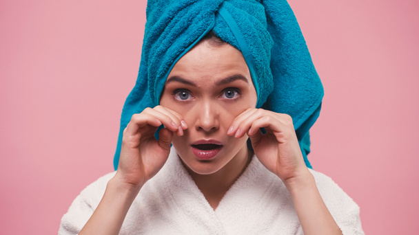 young woman with terry towel on head touching face isolated on pink - Фото, изображение