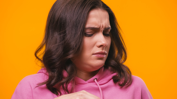 displeased woman feeling disgusted while feeling stinky smell isolated on yellow - Photo, Image