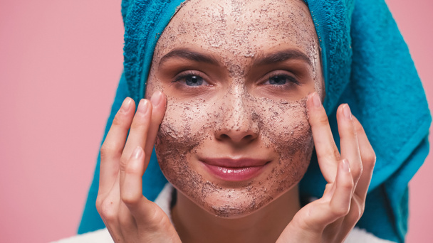 close up view of positive young woman applying face scrub isolated on pink - Fotografie, Obrázek