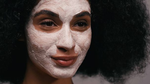primo piano di donna afro-americana con maschera di argilla sul viso - Foto, immagini