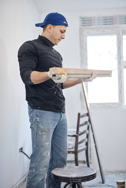 Jeune homme adulte travaillant sur une rénovation de budget bricolage de son nouvel appartement à la maison. - Photo, image