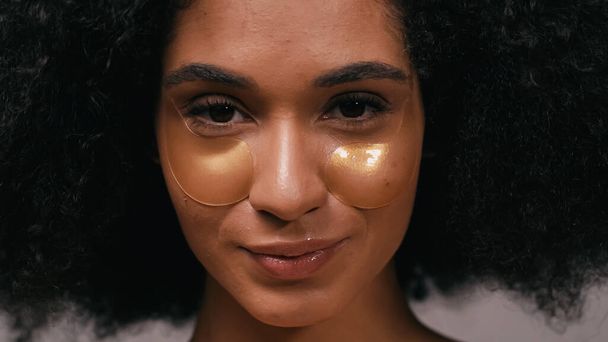 крупным планом африканской американки с увлажняющими повязками на глазах, смотрящей в камеру - Фото, изображение