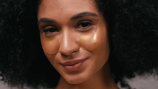 close up of happy african american woman with moisturizing eye patches  - Foto, Bild