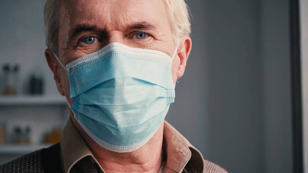 close up of senior man with blue eyes in medical mask  - 写真・画像