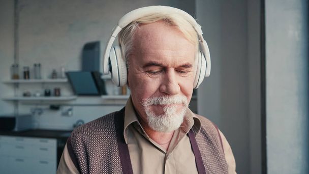 bearded and senior man in wireless headphones listening music - 写真・画像