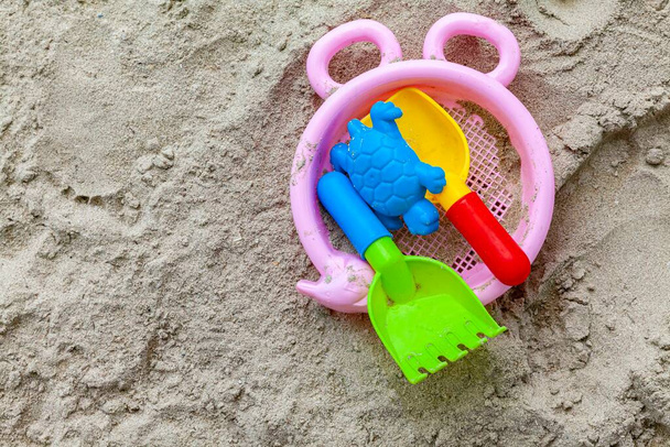 砂の上のプラスチック製の子供のおもちゃ - 写真・画像