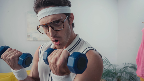 athletic man exercising with dumbbells at home, retro sport concept  - Fotografie, Obrázek