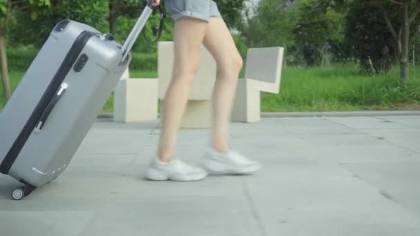 жіночі ноги ходять на тротуарі і несуть за собою валізу
. - Кадри, відео