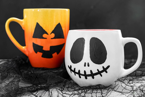 Mug with scary Jacks face. Halloween background. - Photo, Image