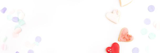 Herzförmige Plätzchen mit buntem Festkonfetti bieten Platz für Text und Gestaltung. Valentinstag, Datum, Hochzeit, Liebes-Hintergrund. Pastellfarben - Foto, Bild