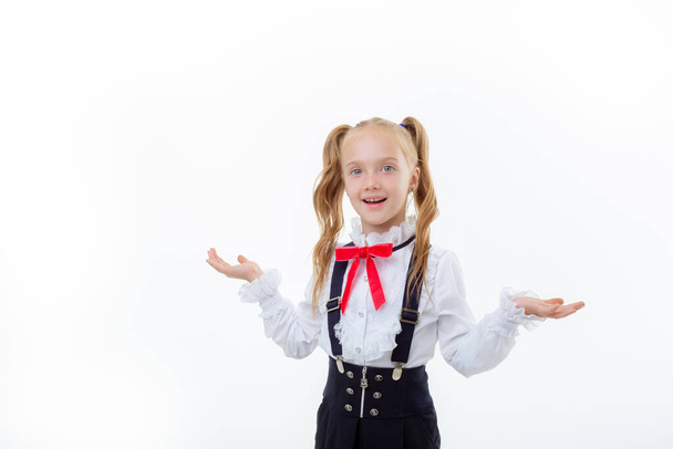 a little schoolgirl girl in a school uniform is isolated on a white background - 写真・画像