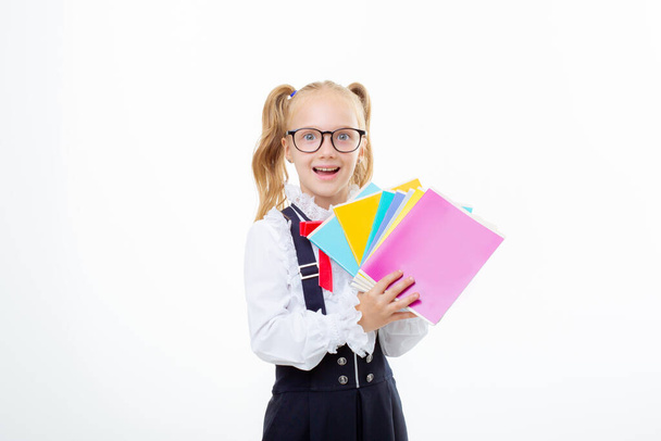 egy kis iskolás lány tart notebook fehér háttér elszigetelt - Fotó, kép