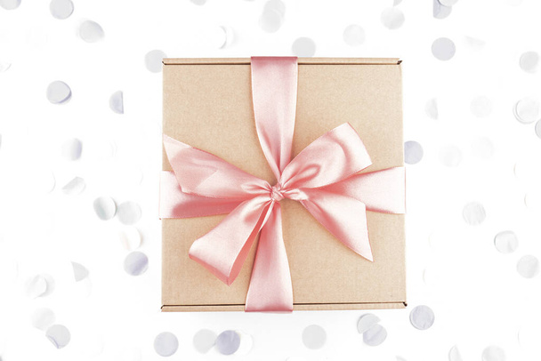 cadeau boîte cadeau avec arc rose avec confettis festifs. Anniversaire, désherbage, vacances de Noël et concept de félicitations. Style de pose plat. - Photo, image