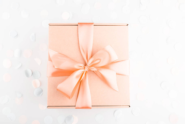 δώρο κουτί με ροζ φιόγκο με εορταστικά κομφετί. Γενέθλια, βοτάνισμα, χριστουγεννιάτικες διακοπές και συγχαρητήρια. Επίπεδο στυλ lay. - Φωτογραφία, εικόνα