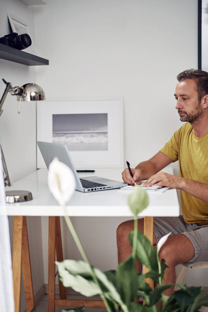 Adult caucasian man working on a laptop at home. - Valokuva, kuva