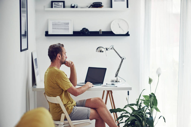 Homem caucasiano adulto trabalhando em um laptop em casa. - Foto, Imagem