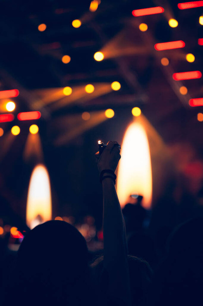 Persona sosteniendo encendedor en un concierto. - Foto, imagen