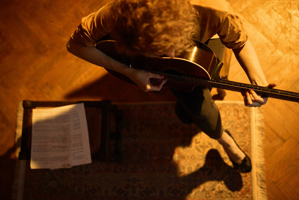 Žena hraje na akustickou kytaru v retro vintage místnosti. - Fotografie, Obrázek