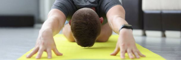 Young man is doing exercises to stretch his back muscles - Photo, Image