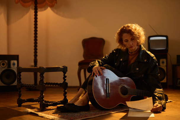 Frau spielt Akustikgitarre im Retro-Vintage-Raum. - Foto, Bild