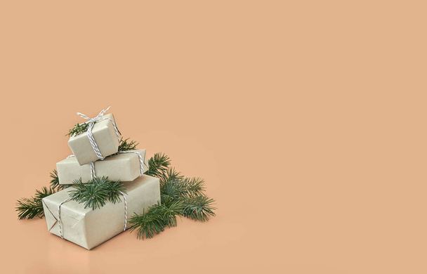 Cajas de regalo de Navidad y abeto sobre fondo beige - Foto, imagen