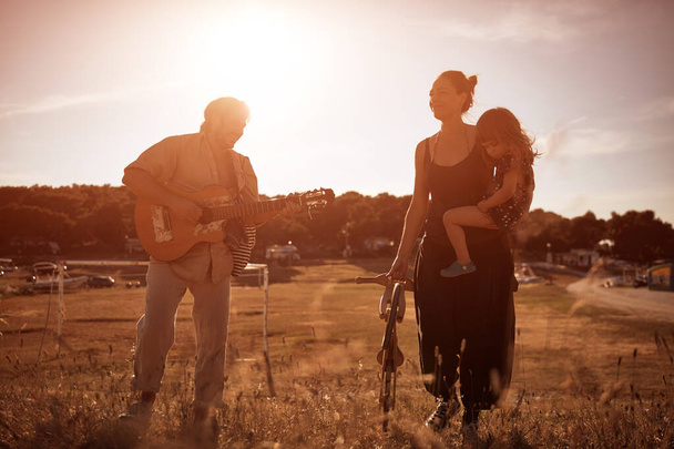 Familia en vacaciones, cantando, tocando música en una guitarra y disfrutando de vibraciones veraniegas. - Foto, imagen