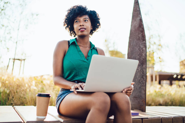 Webページやブログのコンテンツ作成を考えながら、アフリカ系アメリカ人女性のデジタルノマドについて考えてみると、パソコンでオンラインコースを閲覧するペシャルダークスキンの女性学生    - 写真・画像