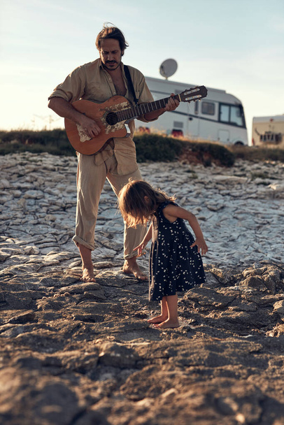 Vater mit Tochter musiziert, singt Lieder und genießt sommerliche Stimmung. - Foto, Bild