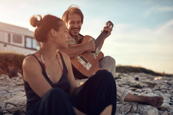 Man singing to his girlfriend on a beach. - Фото, зображення