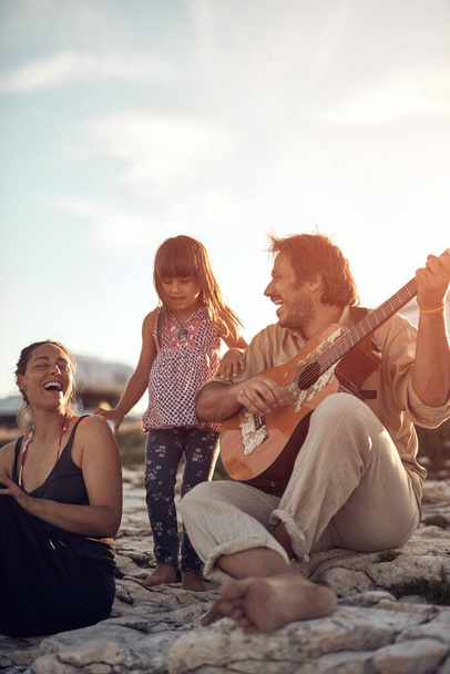 Famille en vacances, chanter, jouer de la musique à la guitare et profiter des vibrations estivales. - Photo, image