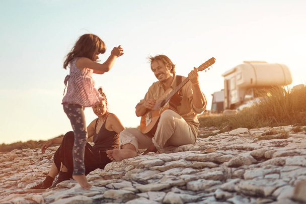 Famiglia in vacanza, cantare, suonare musica con la chitarra e godersi le vibrazioni estive. - Foto, immagini