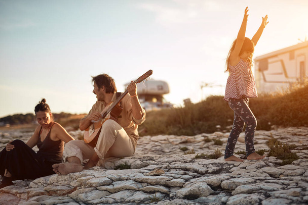 Family on a vacation, singing, playing music on a guitar and enjoying summertime vibes. - Fotó, kép