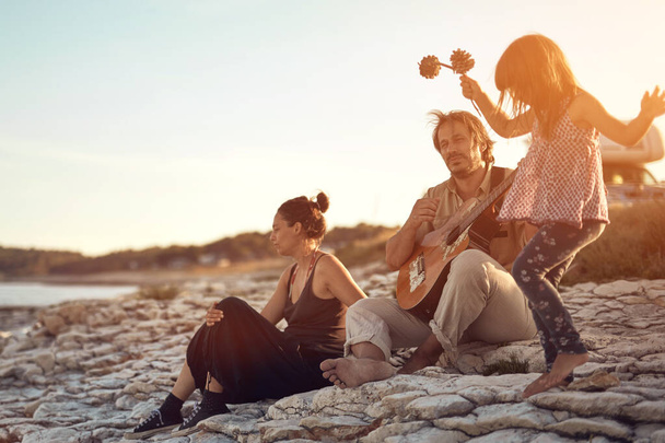 Familia en vacaciones, cantando, tocando música en una guitarra y disfrutando de vibraciones veraniegas. - Foto, Imagen