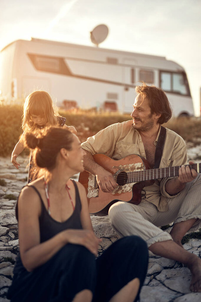 Rodina na dovolené, zpívá, hraje na kytaru a užívá si letní vibrace. - Fotografie, Obrázek