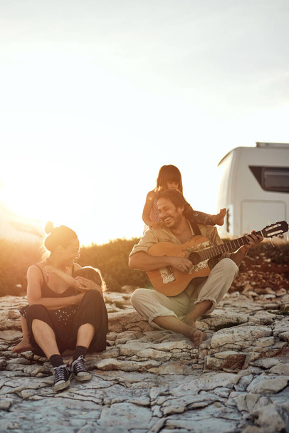 Famille en vacances, chanter, jouer de la musique à la guitare et profiter des vibrations estivales. - Photo, image