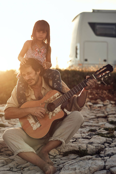 Ojciec z córką grający muzykę, śpiewający piosenki i cieszący się letnimi wibracjami. - Zdjęcie, obraz