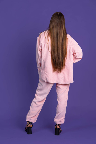 後ろの景色。紫色の背景に孤立した若い髪の女性の完全な長さの肖像画 - 写真・画像