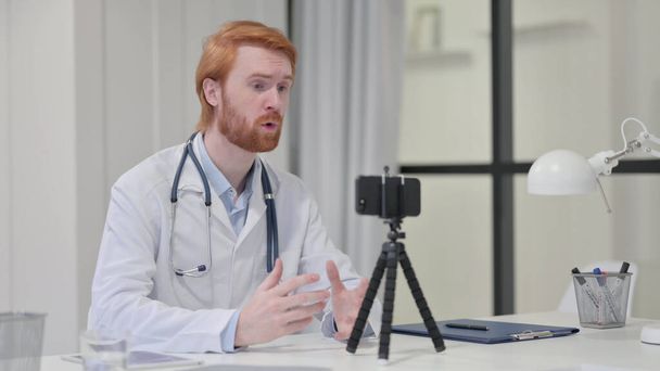 Pelirroja macho doctor grabación vídeo en cámara  - Foto, Imagen