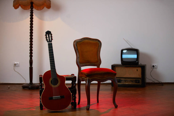 Ακουστική κιθάρα με ρετρό έπιπλα εποχής στο σπίτι. - Φωτογραφία, εικόνα
